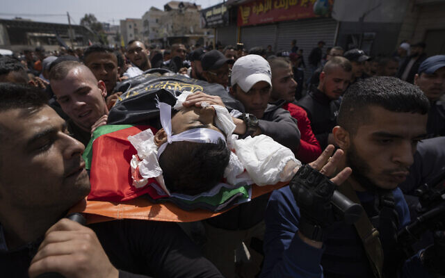 Palestinian mourners carry the body of Sanad Abu Atiyeh, 17 during his funeral in the West Bank refugee camp of Jenin, on March 31, 2022. (AP Photo/Nasser Nasser)