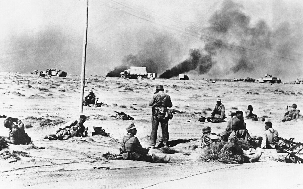 Немецкая пехота сидит на песках пустыни во время отдыха, когда дым валит из обстрелянных позиций вокруг Тобрука 17 июля 1942 года. (Фото AP)