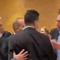 A scuffle between lawmakers in the Knesset plenum's back hallway, March 2, 2022. (screenshot)