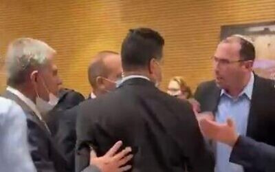 A scuffle between lawmakers in the Knesset plenum's back hallway, March 2, 2022. (screenshot)