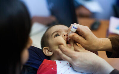 A child is given an oral vaccine for polio in Neve Yaakov, Jerusalem, on September 10 2013. (Yonatan Sindel/Flash90)