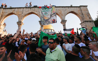 Illustrative: Palestinians hold Hamas flags and banners, and Palestinian flags, near the Al Aqsa Mosque, in Jerusalem's Old City, on July 20, 2021. (Jamal Awad/Flash90)
