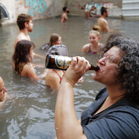 People enjoy a hot mineral water spring in Hamat Gader, northern Israel, on February 5, 2022. (Michael Giladi/Flash90)