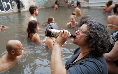 People enjoy a hot mineral water spring in Hamat Gader, northern Israel, on February 5, 2022. (Michael Giladi/Flash90)