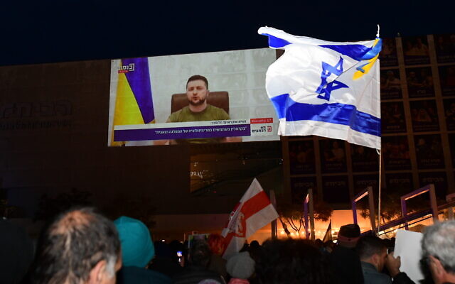 People watch a screening of Ukrainian President Volodymyr Zelensky's address to Knesset members at Habima Square in Tel Aviv, on March 20, 2022. (Avshalom Sassoni/Flash90)