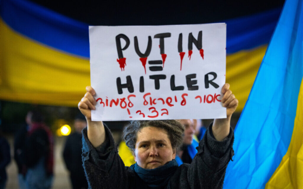 A demonstrator carries a placard reading in Hebrew 'Israel cannot stand to the side' during a protest against the Russian invasion to the Ukraine, outside the city hall in Jerusalem, on February 28, 2022. (Olivier Fitoussi/Flash90)