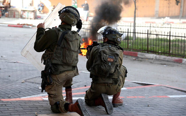 Israeli security forces fire rubber bullets during clashes with Palestinians in the southern West Bank city of Hebron, on March 1, 2022. (Wisam Hashlamoun/Flash90)