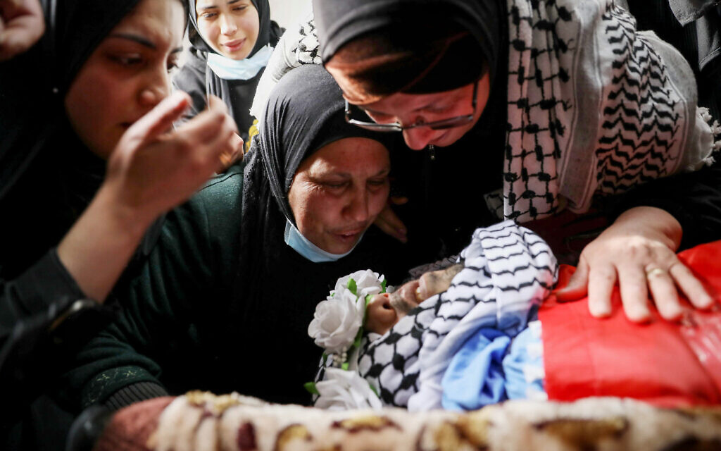 Palestinians mourn near the body of Ammar Shafiq Abu Afifa, who was killed by Israeli security forces near the town of Beit Fajar, during his funeral in the Al-Aroub refugee camp, near the West Bank city of Hebron, March 2, 2022. (Wisam Hashlamoun/ Flash90)