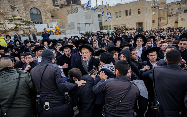 Ultra-Orthodox Jews scuffle with police as they protest members of the Women of the Wall movement bringing in Torah scrolls to their hold Rosh Hodesh service at the Western Wall in Jerusalem's Old City, on March 4, 2022. (Yonatan Sindel/Flash90)