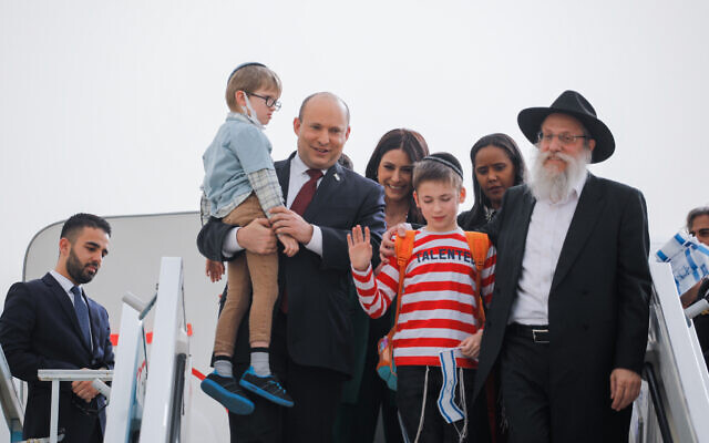 Israeli prime minister Naftali Bennett seen with Jewish immigrants fleeing the war in Ukraine, onm a rescue flight sponosred by the IFCJ, at Ben Gurion airport near Tel Aviv, on March 6, 2022. (Hadas Parush/Pool)