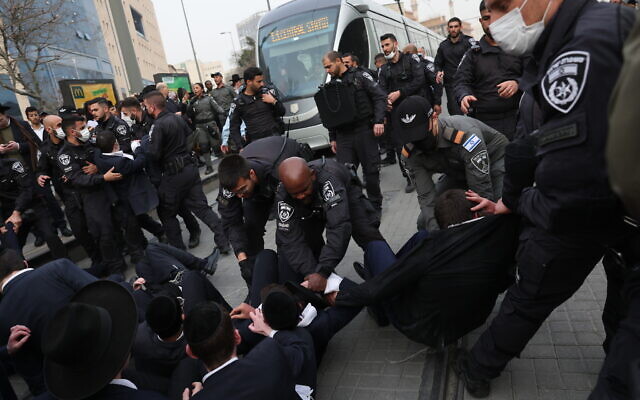 Ultra-Orthodox Jews clash with police as they protest against the arrest of an IDF draft-dodger, in Jerusalem, March 6, 2022. (Yonatan Sindel/Flash90)