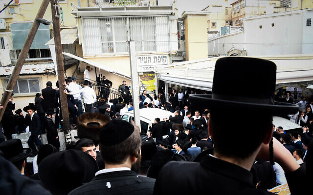People gather outside the home of Rabbi Chaim Kanievsky, in the city of Bnei Brak, on March 18, 2022. (Flash90)