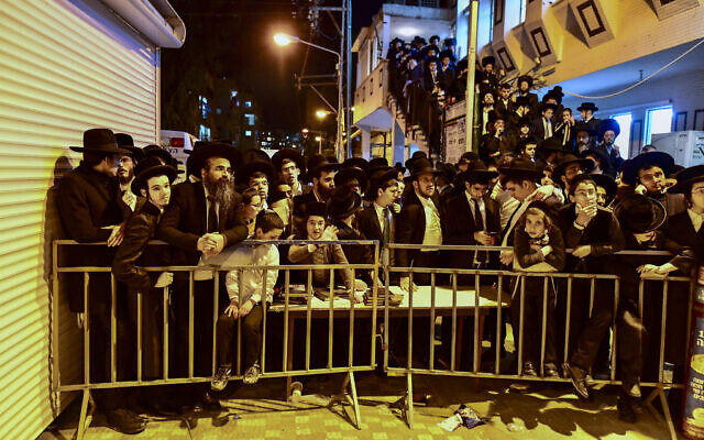 People gather outside the home of Rabbi Chaim Kanievsky who passed away, in the city of Bnei Brak, on March 19, 2022. (Avshalom Sassoni/ Flash90)