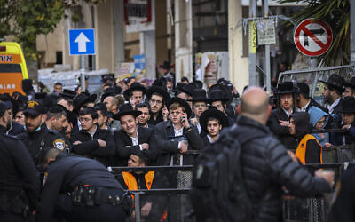 Men gather outside the home of Rabbi Chaim Kanievsky on March 20, 2022 (Yonatan Sindel/ Flash90)