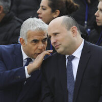 Prime Minister Naftali Bennett and Foreign Minister Yair Lapid (L) attend a departure ceremony for an Israeli delegation flying out to set up a field hospital in Ukraine at Ben Gurion Airport, on March 21, 2022. (Marc Israel Sellem/Pool/Flash90)