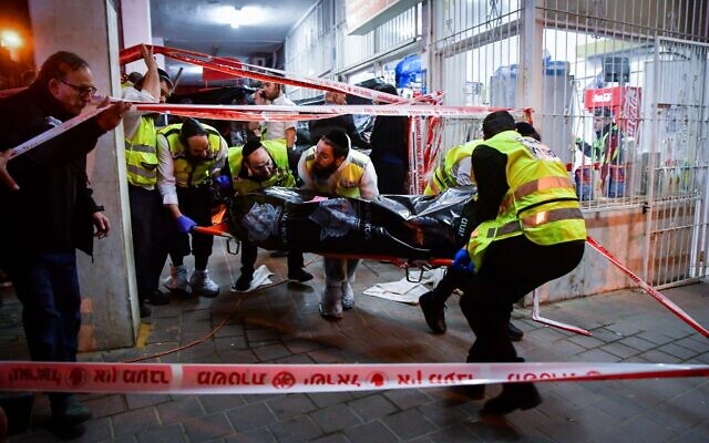 Members of the Zaka emergency organization remove a body from the scene of a shooting attack in Bnei Brak, March 29, 2022. (Avshalom Sassoni/Flash90)