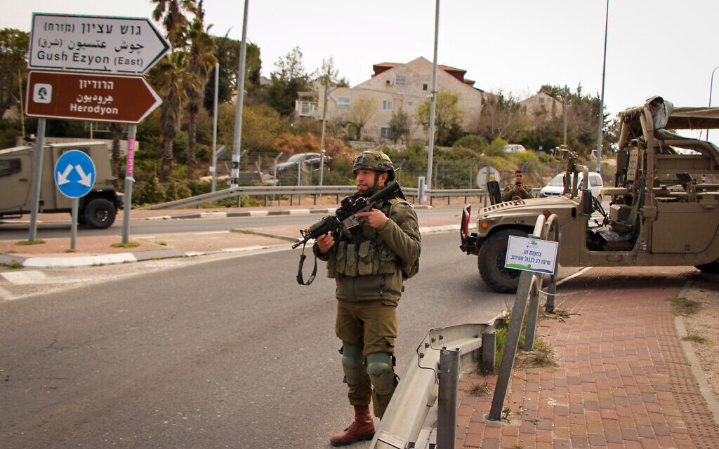 Illustrative: Israeli soldiers stand guard at the entrance to the Efrat settlement in the central West Bank on March 29, 2022. (Gershon Elinson/Flash90)