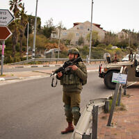Illustrative: Israeli soldiers stand guard at the entrance to the Efrat settlement in the central West Bank on March 29, 2022. (Gershon Elinson/Flash90)