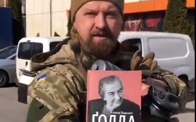 A Ukrainian officer shows off a biography of Golda Meir that he carries into battle with him. (Screen capture: Twitter)