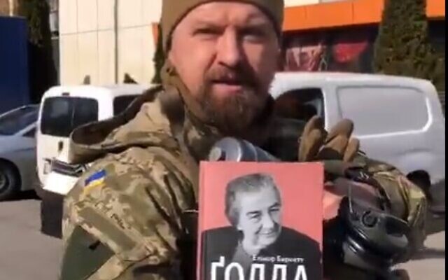 A Ukrainian officer shows off a biography of Golda Meir that he carries into battle with him. (Screen capture: Twitter)