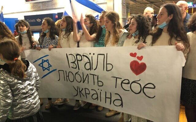 Israelis gather at Ben Gurion Airport to welcome a group of Ukrainian refugees arriving on a rescue flight organized by United Hatzalah, on March 3, 2022. (The Times of Israel)
