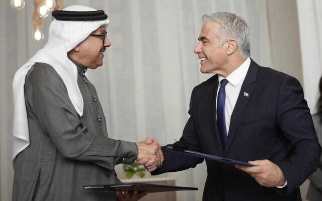 Foreign Minister Yair Lapid (R) and his Bahraini counterpart  shake hands after signing a framework agreement on future bilateral cooperation, on the sidelines of the Negev Summit at Sde Boker, southern Israel, March 28, 2022. (Boaz Oppenheim/GPO)