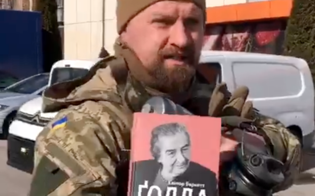 A Ukrainian soldier nicknamed Zion holds up a copy of a Golda Meir biography he carries with him into battle, on March 8, 2022. (Screenshot/Twitter)