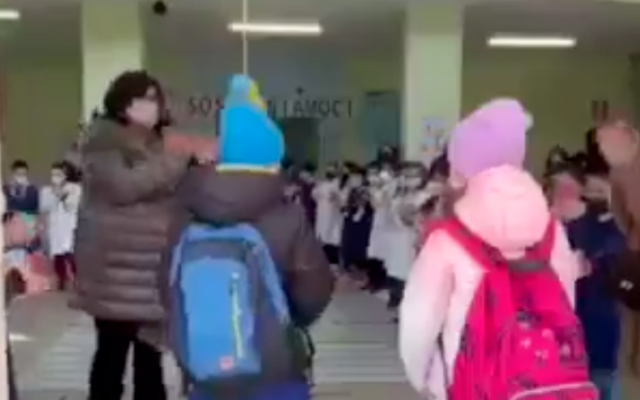 Ukrainian refugees are met with applause upon their arrival to a school in Italy in March 2022. (Screen capture/Twitter)