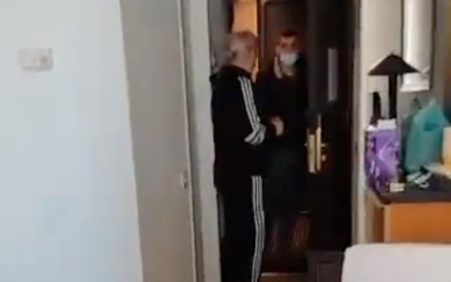 A Population Immigration and Border Authority official arrives at the hotel room of a Ukrainian refugee in Tel Aviv in order to deport her on March 14, 2022. (Screen capture/Twitter)