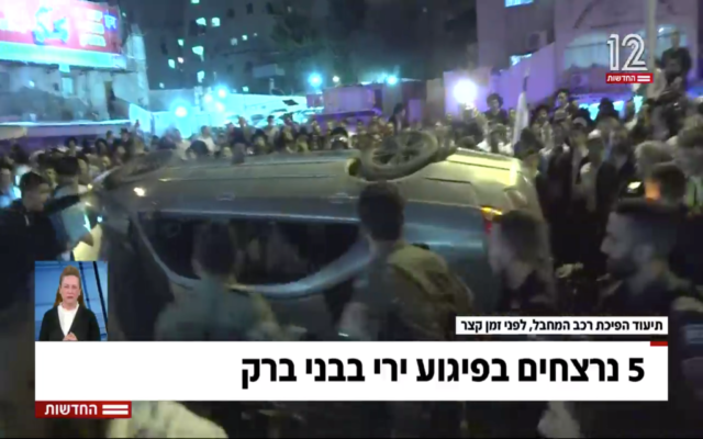 A Bnei Brak crowd takes out their anger on a vehicle suspected of having belonged to the shooter in a terror attack, on March 29, 2022. (Screen capture/Channel 12)