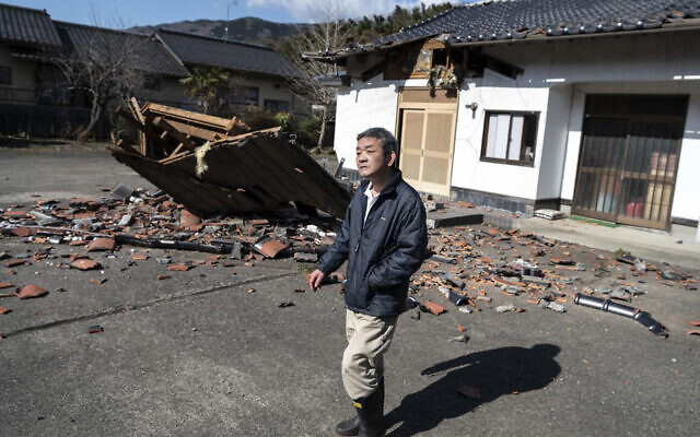 Sushi maker Akio Hanzawa walks in front of his damaged restaurant in Shiroishi, Miyagi prefecture on March 17, 2022, after a 7.3-magnitude earthquake jolted east Japan the night before. (Charly Triballeau/AFP)