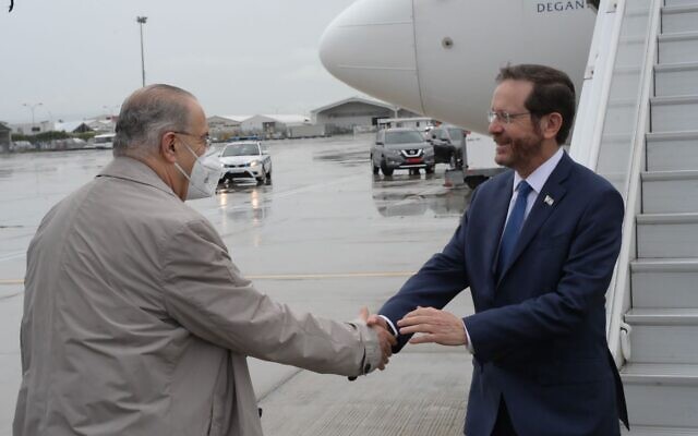 President Isaac Herzog is received at an 
airport in Cyprus by Cypriot Minister of Foreign Affairs, Ioannis Kasoulides, March 2. 2022. (Amos Ben Gershom/GPO)
