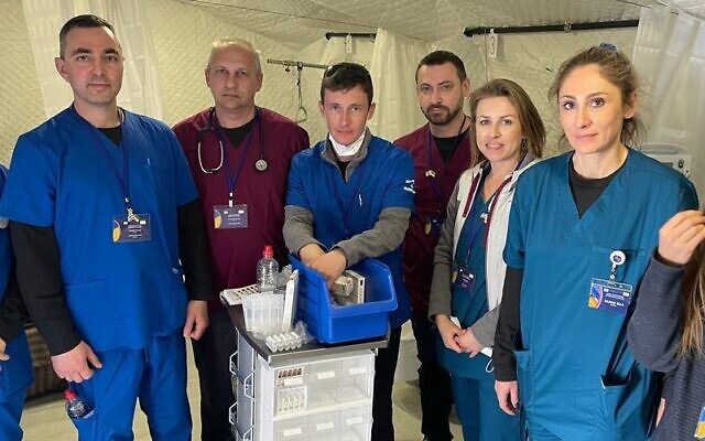 Medical staff, Ukrainian and Israeli government representatives, and patients on site at Israel's state field hospital in Mostyska, Ukraine, which opened, March 22, 2022. (Carrie Keller-Lynn/The Times of Israel)