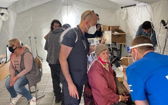 Medical staff, Ukrainian and Israeli government representatives, and patients on site at Israel's field hospital in Mostyska, Ukraine, March 22, 2022. (Carrie Keller-Lynn/The Times of Israel)