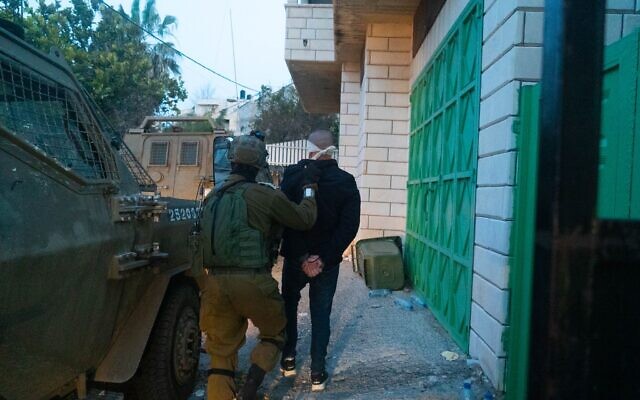Soldiers detain a suspect in the West Bank town of Ya’bad near Jenin, following a deadly terror attack in Bnei Brak, March 30, 2022. (Israel Defense Forces)