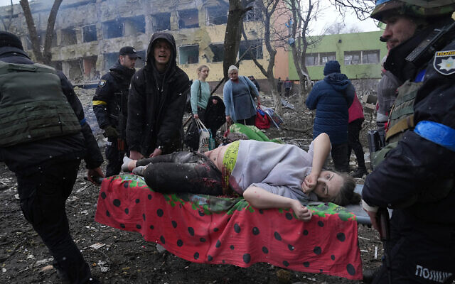 Ukrainian emergency employees and volunteers carry an injured pregnant woman from maternity hospital destroyed by Russian bombing in Mariupol, Ukraine, March 9, 2022. (AP Photo/Evgeniy Maloletka)