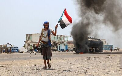 File: In this photo taken on August 30, 2019 A fighter of the UAE-trained Security Belt Force, dominated by members of the Southern Transitional Council (STC) which seeks independence for south Yemen, walks with a separatist flag past an oil tanker set ablaze during clashes between the separatists and the Saudi-backed government forces at the Fayush-Alam crossroads on the eastern entrance Aden from the Abyan province in southern Yemen. (Nabil HASAN / AFP)