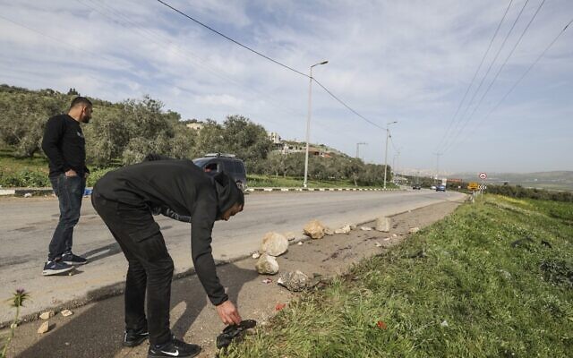 Palestinian men check blood stains left on the ground in the area where Israeli security forces reportedly killed three Islamic Jihad gunmen when they came under fire, on April 2, 2022, near the northern West Bank city of Jenin. (JAAFAR ASHTIYEH / AFP)