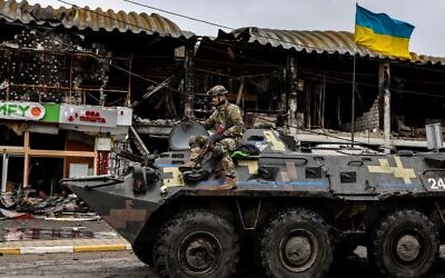 A Ukrainian soldier patrols in an armored vehicle on a street in Bucha, northwest of Kyiv, on April 2, 2022. (Ronaldo Schemidt/AFP)