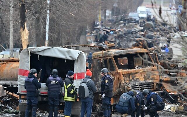 Field engineers of the State Emergency Service of Ukraine conduct mine clearing among destroyed vehicles on a street of Bucha on April 5, 2022, as Ukrainian officials say over 400 civilian bodies have been recovered from the wider Kyiv region, many of which were buried in mass graves (Genya SAVILOV / AFP)