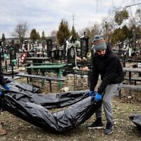 Workers line up bodies for identification by forensic personnel and police officers in the cemetery in Bucha, north of Kyiv, on April 6, 2022, after hundreds of civilians were found dead in areas from which Russian troops have withdrawn around Ukraine's capital, including the town of Bucha. (Ronaldo Schemidt/AFP)