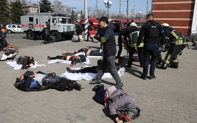 Emergency personnel walk among injured people lying on the platform in the aftermath of a rocket attack on the railway station in the eastern city of Kramatorsk, in the Donbass region on April 8, 2022. (Anatolii STEPANOV / AFP)