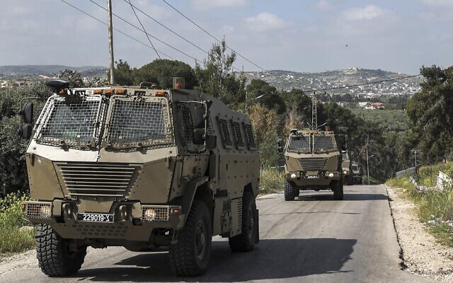 Israeli military vehicles drive in the Jenin refugee camp in the northern West Bank, on April 9, 2022. (Jaafar Ashtiyeh/AFP)