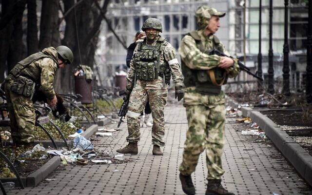 Russian soldiers walks along a street in Mariupol on April 12, 2022. (Alexander Nemenov/AFP)