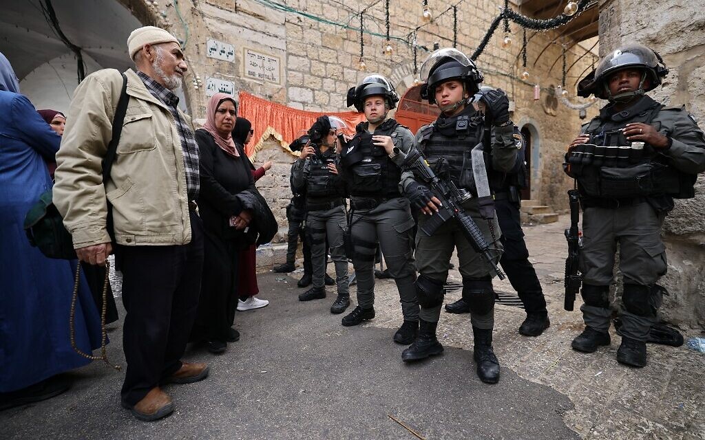 Palestinians face Israeli Border Police officers as they patrol the area in front of the Lion's Gate in Jerusalem's Old City, on April 17, 2022. (Ahmad Gharabli/AFP)