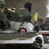 Ukrainian soldiers stand on their armored personnel carrier, not far from the front-line with Russian troops, in Izium district, Kharkiv region, on April 18, 2022, during the Russian invasion of Ukraine. (Anatolii Stepanov/AFP)