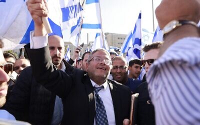 MK Itamar Ben Gvir, leader of the far-right Otzma Yehudit (Jewish Power) faction of the Religious Zionist party, raises an Israeli flag in Safra Square in Jerusalem on April 20, 2022, at the start of a planned nationalist march. (Menahem Kahana / AFP)