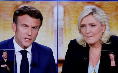 A picture shows screens displaying a live televised debate between incumbent French President Emmanuel Macron (L) and far-right candidate Marine Le Pen (R), broadcasted on French TV channels TF1 and France 2, in a viewing room at the studios hosting the debate in Saint-Denis, north of Paris. (Ludovic Marin/AFP)