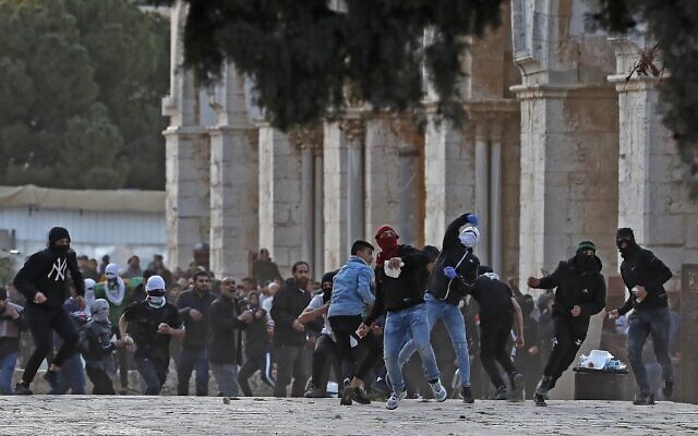 Palestinian clash with Israeli police at the Temple Mount compound in Jerusalem's Old City on April 22, 2022. (Ahmad Gharabli/AFP)