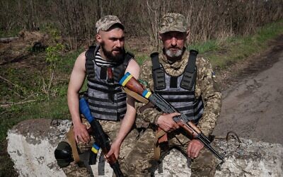 Ukrainian servicemen Vasyl, 51, and his son Denys, 22, (L) pose at a checkpoint near Barvinkove, eastern Ukraine, on April 25, 2022, amid the Russian invasion of Ukraine. (Yasuyoshi Chiba/AFP)